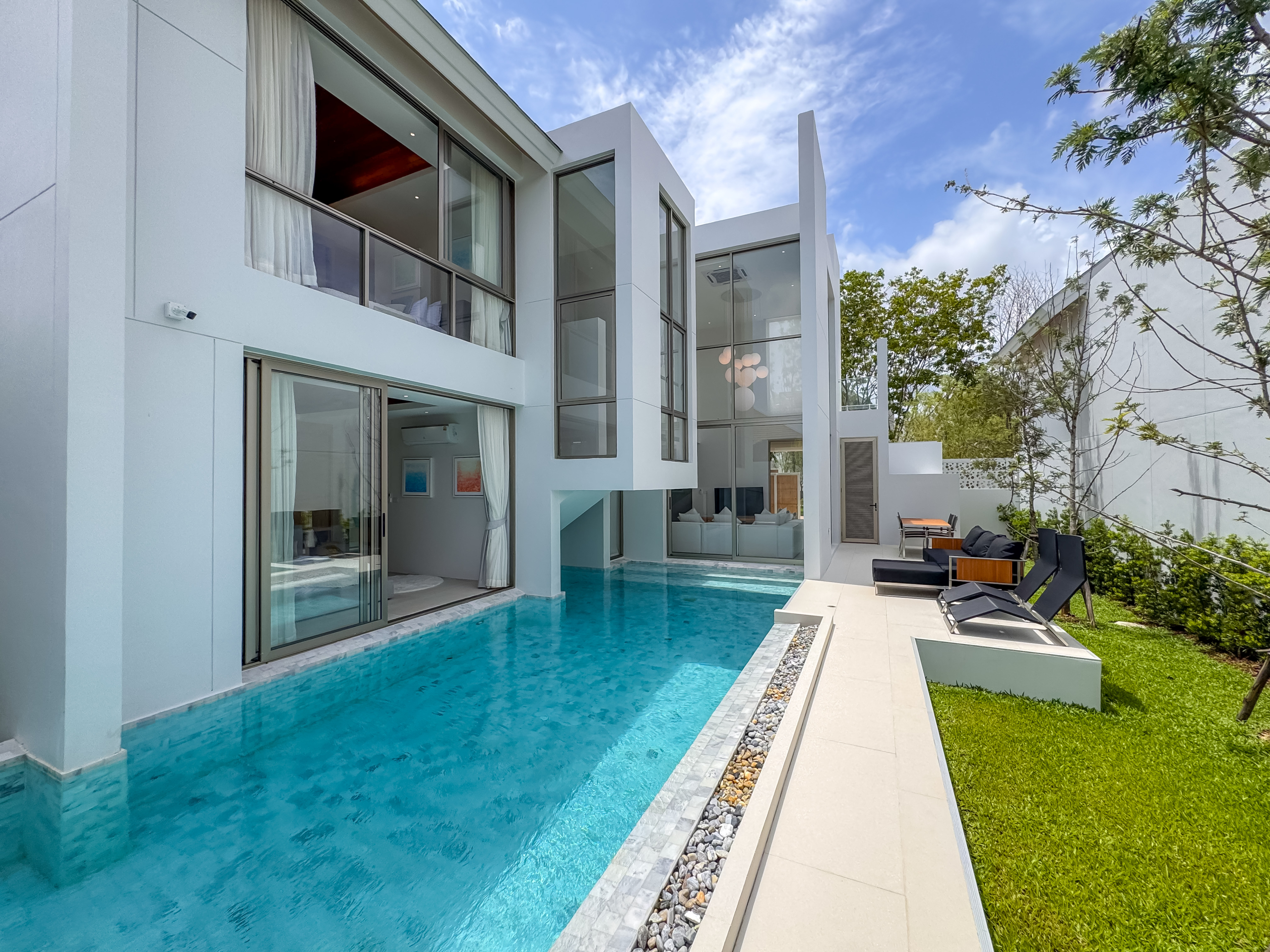 Luxury Modern Villa with Private Pool in Phuket Modern white villa in Phuket with private pool, sun loungers, and green garden area